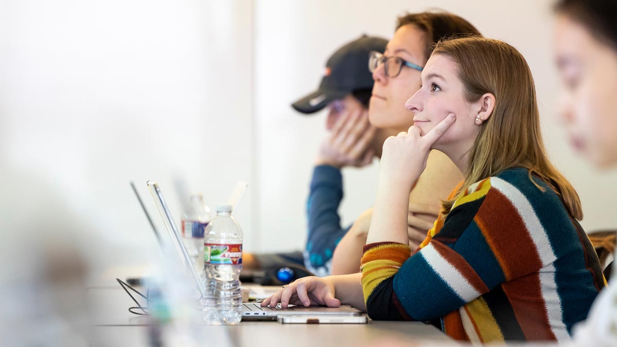 Students listen attentively in a classroom.